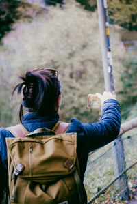 Rear view of woman photographing