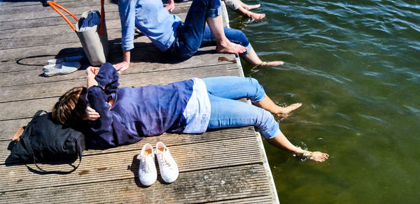 High angle view of people sitting by lake