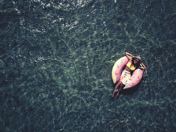 Directly above shot of woman on inflatable ring floating in sea