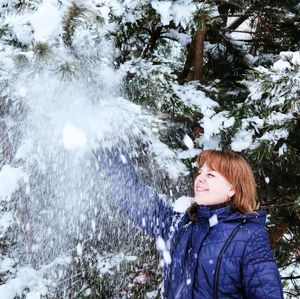 Cute boy standing in snow during winter