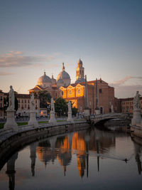 Reflection of buildings in water at sunrise