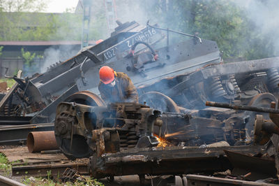 Worker welding scrap metal