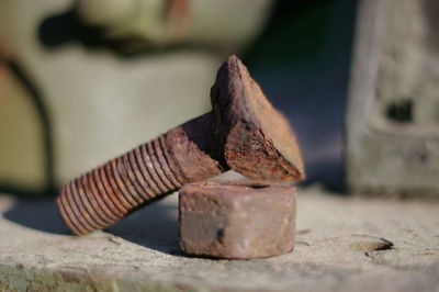 Close-up of rusty bolt with nut on floor