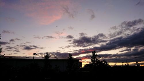 Silhouette of water tower against sky during sunset