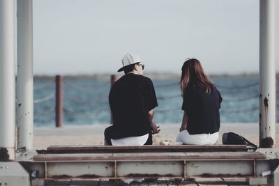 Rear view of people looking at sea against sky