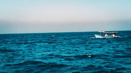 Boat sailing in sea against sky