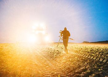 Photographer in front of bright lights of a tractor 