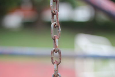 Close-up of chain hanging on metal fence