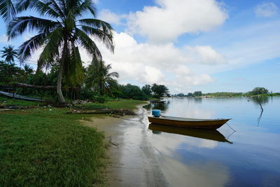 Boat moored on shore against sky