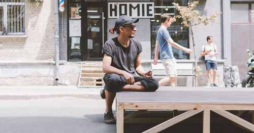 Full length of friends sitting on wall