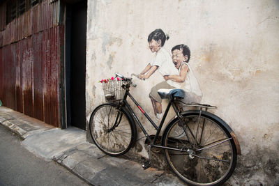 Bicycle parked against wall in city