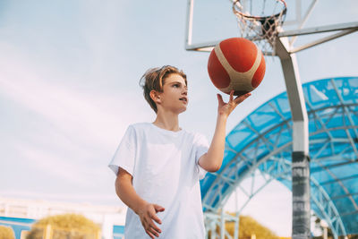 Boy playing with basketball at court