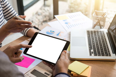 Business people using digital tablet at table in office