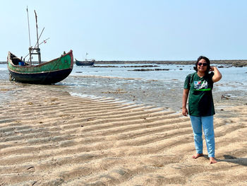 Traveller woman standing on sand waves in the sea