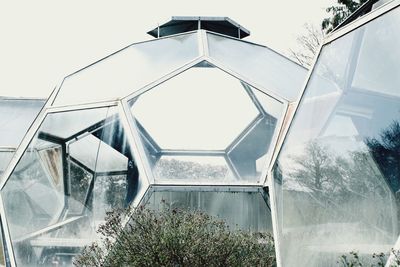 Low angle view of glass building against sky