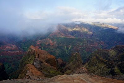Scenic view of mountains and canyon against cloudy sky in hawaii
