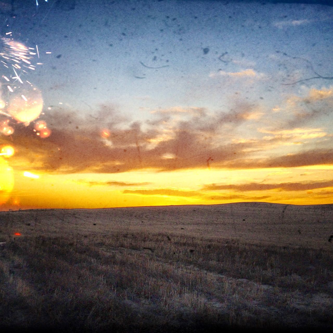 sunset, orange color, scenics, tranquil scene, sky, beauty in nature, tranquility, sun, idyllic, nature, cloud - sky, landscape, horizon over water, dramatic sky, sea, field, cloud, water, yellow, outdoors