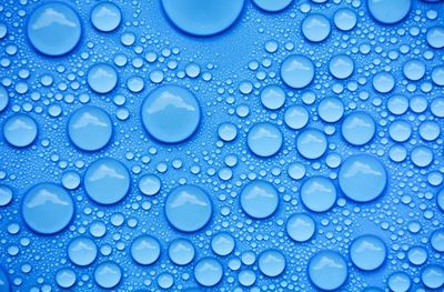 Close-up of water drops on blue surface