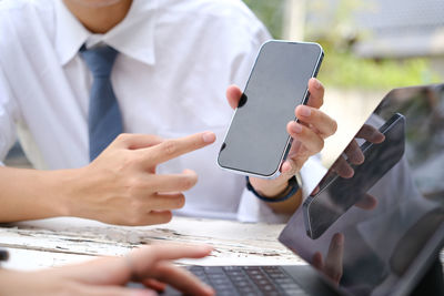 Midsection of businessman using mobile phone