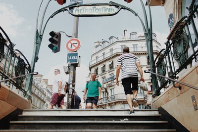 Rear view of people walking on staircase in city