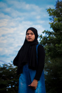 Portrait of woman standing against sky