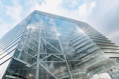 Low angle view of modern building against cloudy sky