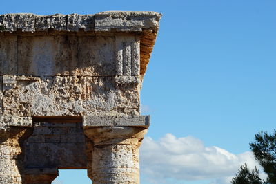 Low angle view of old ruin building against blue sky