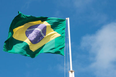 Low angle view of brazilian flag against blue sky