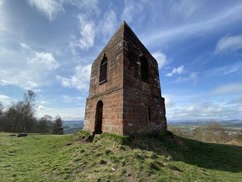 Old building on field against sky