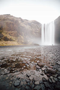 Scenic view of waterfall against sky