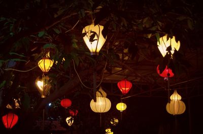 Low angle view of illuminated lanterns hanging at night