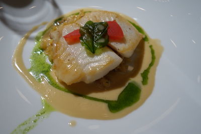 Close-up of cooked fish with sauce on plate