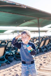 Boy blowing bubble at beach