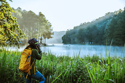 Rear view of man in lake against sky