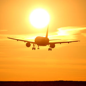 Low angle view of airplane against sunset