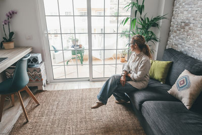 Portrait of woman sitting on sofa at home