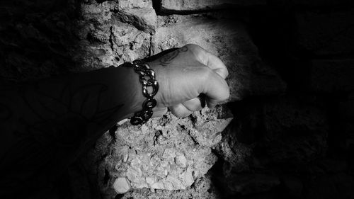 High angle view of woman hand on rock