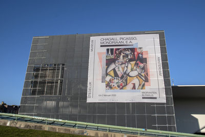 Low angle view of text on building against clear sky