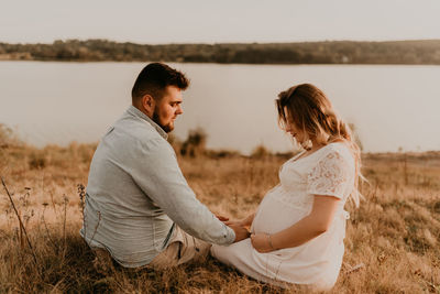 Side view of couple standing on field