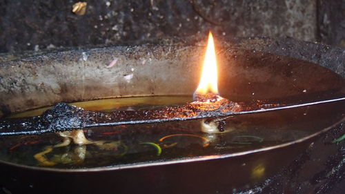 Close-up of lit candles in water