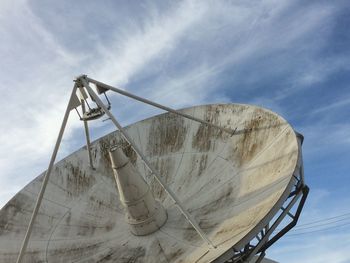 Low angle view of satellite dish against cloudy sky