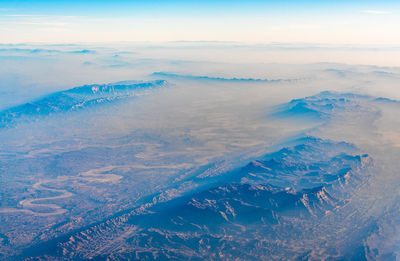 Aerial view of landscape by sea against sky