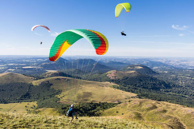 Paragliders at the top of the puy de dôme with a view of the puys chain in the massif central 