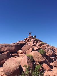 Built structure on rock against clear blue sky