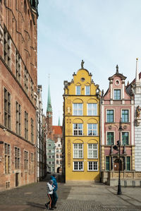 Woman on street against buildings in city
