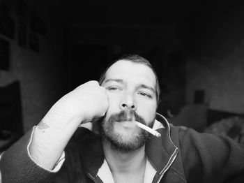 Portrait of young man smoking cigarette