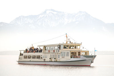 Boat sailing on sea against mountains