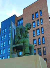 Low angle view of statue against building in city
