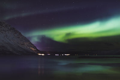 Scenic view of sea against sky 
aurora borealis at night