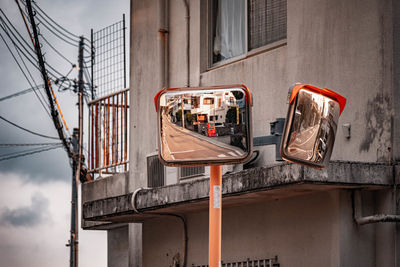 Low angle view of telephone booth against building in city